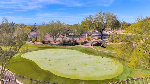 surrounding community with golf course view and fence