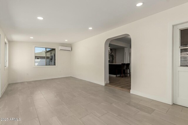 2240 W Cheery Lynn Rd, Phoenix, AZ 85015 - empty room featuring arched walkways, a wall mounted AC, and recessed lighting