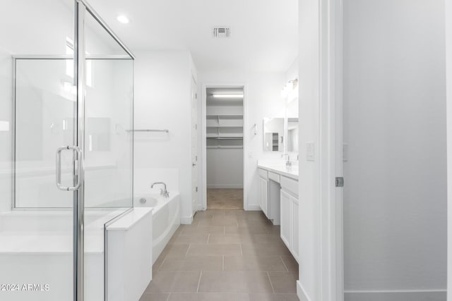 bathroom featuring shower with separate bathtub, vanity, and tile patterned floors