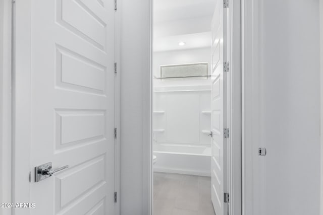 bathroom with toilet, shower / tub combination, and tile patterned floors