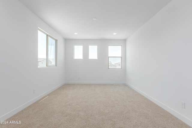 carpeted spare room featuring plenty of natural light