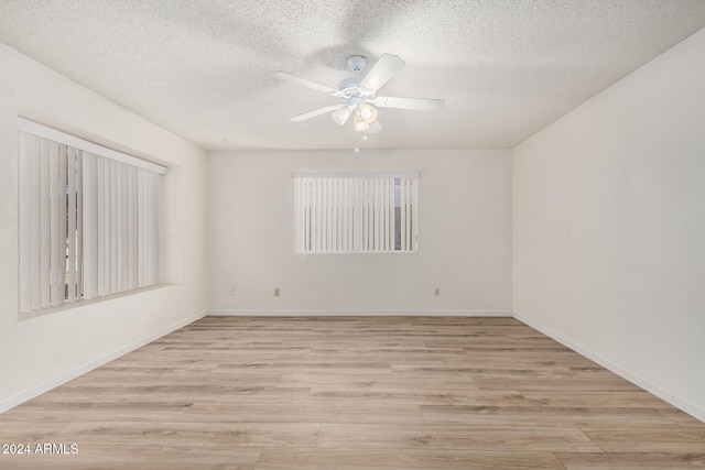 empty room featuring a textured ceiling, light hardwood / wood-style flooring, and ceiling fan