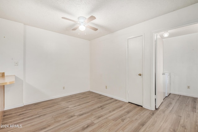 spare room featuring a textured ceiling, light hardwood / wood-style flooring, and ceiling fan