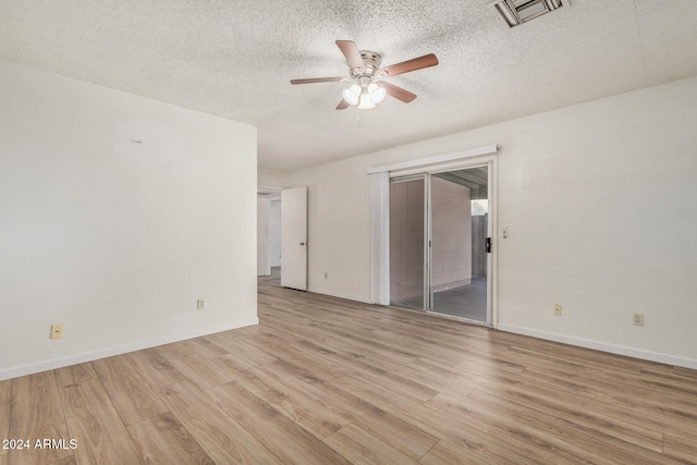 spare room with ceiling fan, light hardwood / wood-style flooring, and a textured ceiling