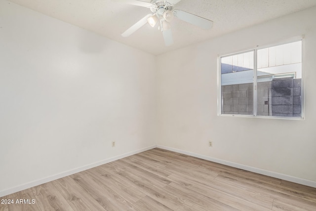 empty room with ceiling fan, a textured ceiling, and light hardwood / wood-style flooring