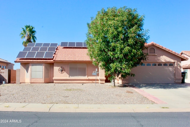 view of front of house featuring solar panels and a garage