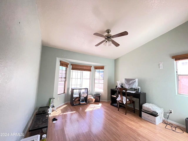 office space featuring light wood-type flooring, lofted ceiling, a textured ceiling, and ceiling fan