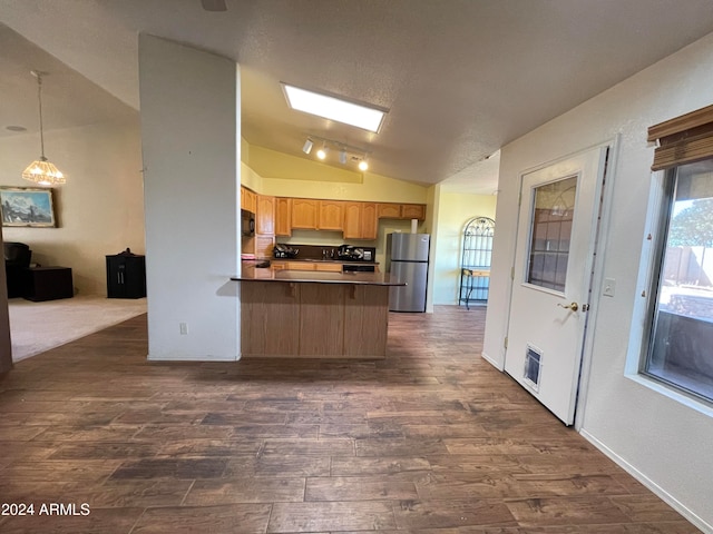 kitchen featuring stainless steel refrigerator, dark hardwood / wood-style flooring, pendant lighting, kitchen peninsula, and lofted ceiling