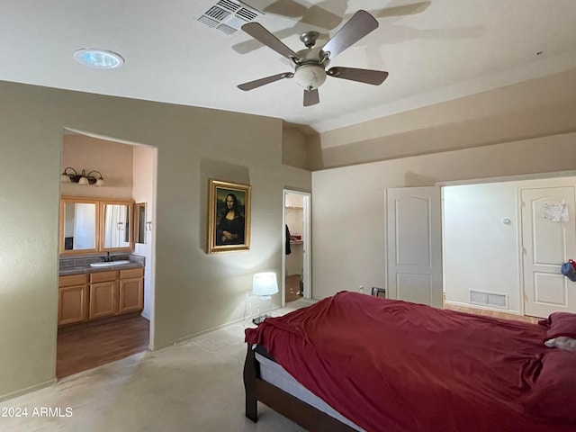 carpeted bedroom featuring ceiling fan, ensuite bath, and sink