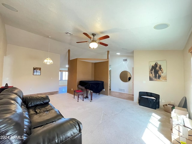 carpeted living room featuring ceiling fan, a textured ceiling, and vaulted ceiling