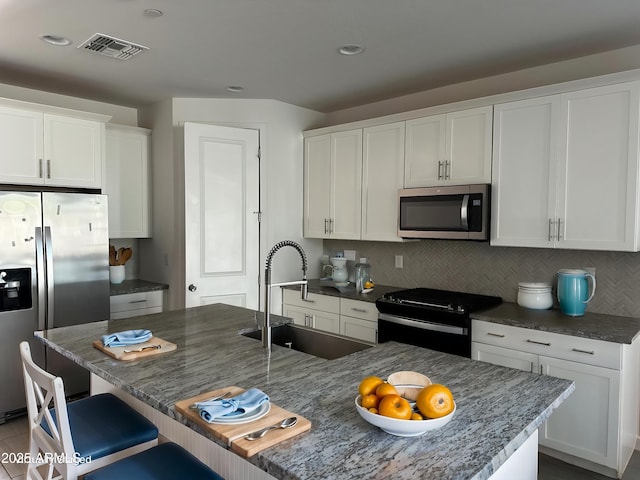 6838 W Pedro Ln, Laveen, AZ 85339 - kitchen with tasteful backsplash, a sink, visible vents, and stainless steel appliances