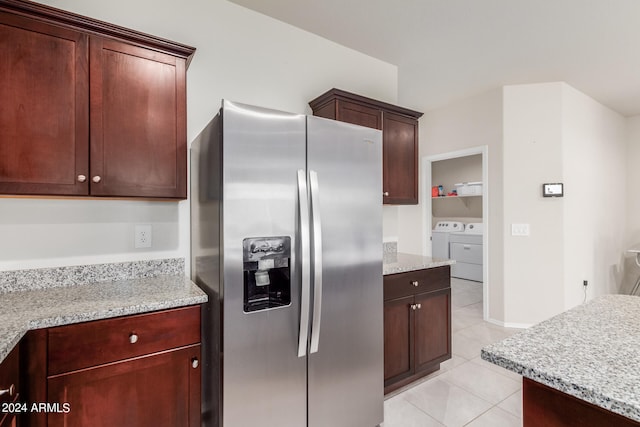 kitchen with stainless steel fridge with ice dispenser, separate washer and dryer, light tile floors, and light stone countertops