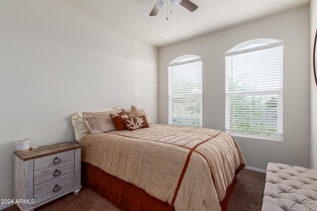 bedroom with lofted ceiling, dark colored carpet, and ceiling fan