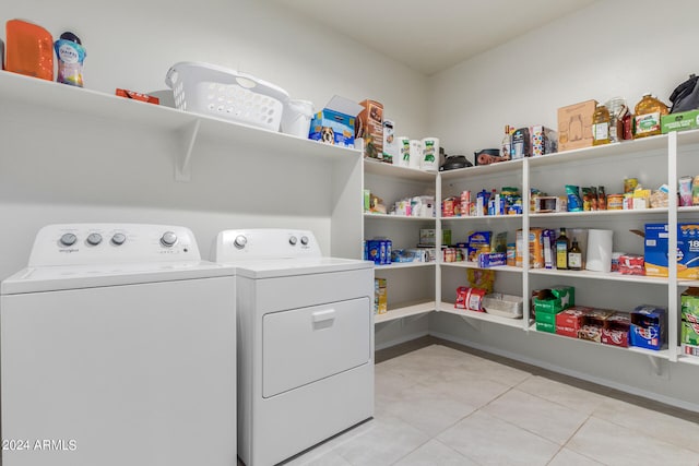 laundry room featuring washer and clothes dryer and light tile floors