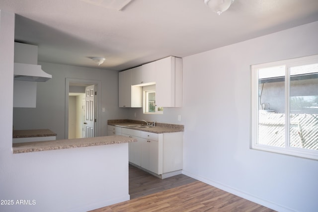 1410 S 24th Ave, Phoenix, AZ 85009 - kitchen featuring baseboards, a sink, white cabinets, and light wood-style floors