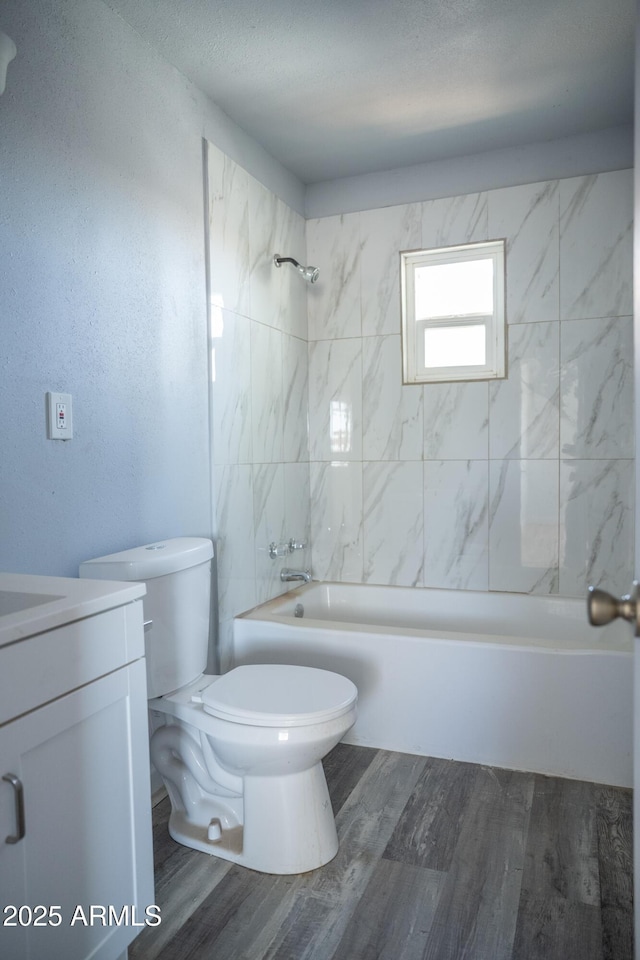 1410 S 24th Ave, Phoenix, AZ 85009 - bathroom featuring wood finished floors, toilet, shower / washtub combination, vanity, and a textured ceiling
