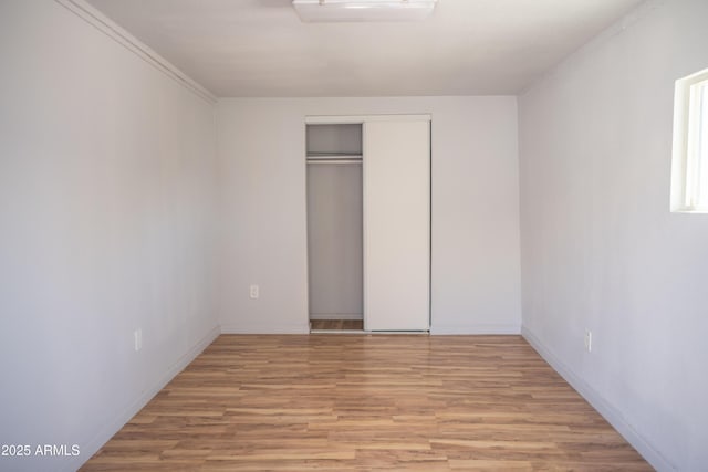 1410 S 24th Ave, Phoenix, AZ 85009 - unfurnished bedroom with wood finished floors, baseboards, and a closet