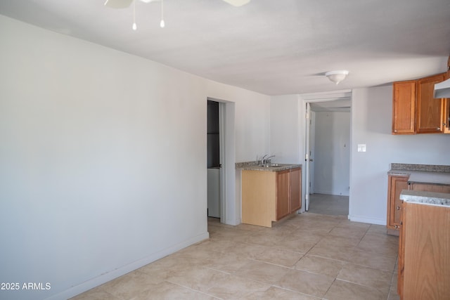 1410 S 24th Ave, Phoenix, AZ 85009 - kitchen featuring light tile patterned floors, brown cabinets, a sink, baseboards, and a ceiling fan