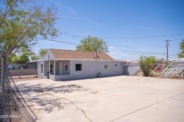 1410 S 24th Ave, Phoenix, AZ 85009 - rear view of house featuring driveway, a shingled roof, stucco siding, and fence