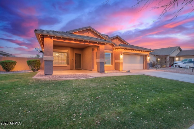 view of front of property with a garage and a lawn