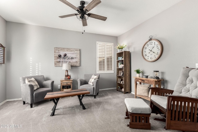 living area featuring a ceiling fan, baseboards, and carpet flooring