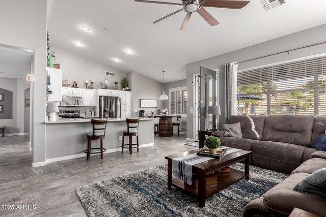 living area featuring a wealth of natural light, visible vents, and a ceiling fan