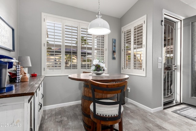 dining area with baseboards and wood finished floors