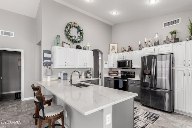 kitchen with visible vents, appliances with stainless steel finishes, arched walkways, and a sink