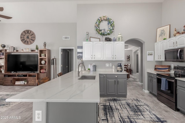 kitchen featuring appliances with stainless steel finishes, a sink, visible vents, and gray cabinetry