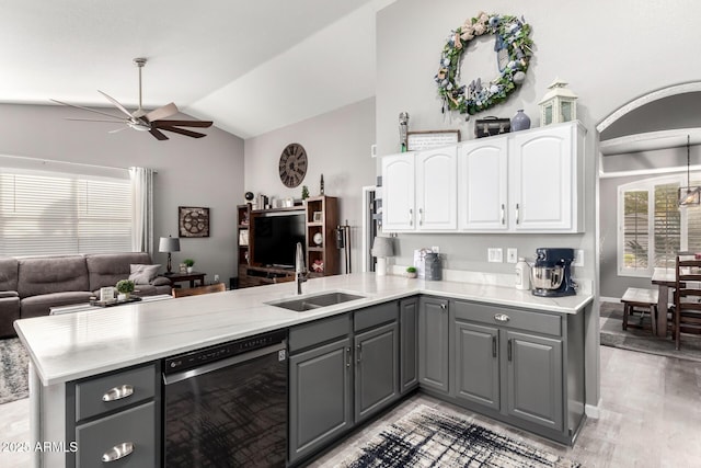 kitchen with a peninsula, dishwashing machine, a sink, and gray cabinetry