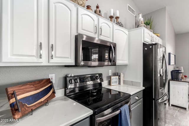 kitchen featuring white cabinetry, stainless steel appliances, and light countertops