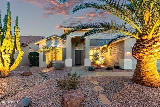 view of front of property with an attached garage and stucco siding