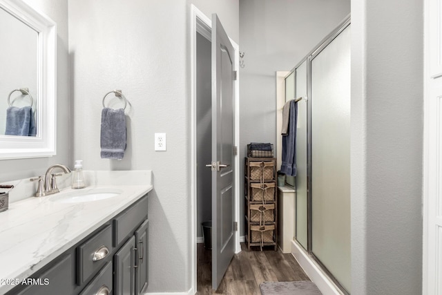 full bath featuring a shower stall, vanity, and wood finished floors