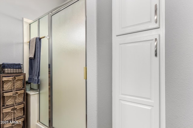 bathroom featuring a stall shower and a textured wall