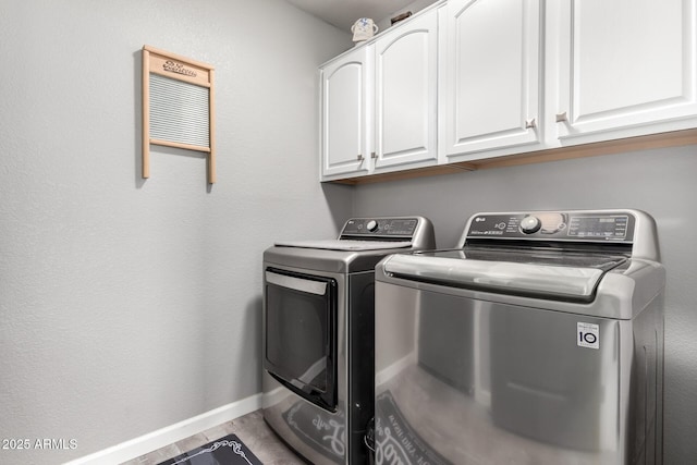 laundry area with cabinet space, washing machine and dryer, and baseboards