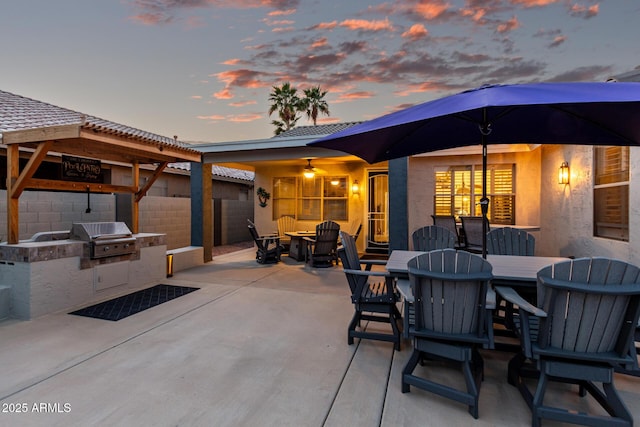 view of patio with outdoor dining area, area for grilling, a grill, and fence