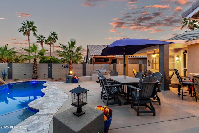 view of pool with a patio, outdoor dining area, a fenced backyard, and a fenced in pool