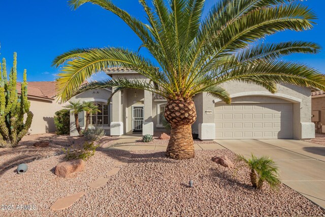 view of front of property featuring a garage, concrete driveway, and stucco siding