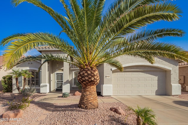 view of front of property featuring a garage, driveway, and stucco siding