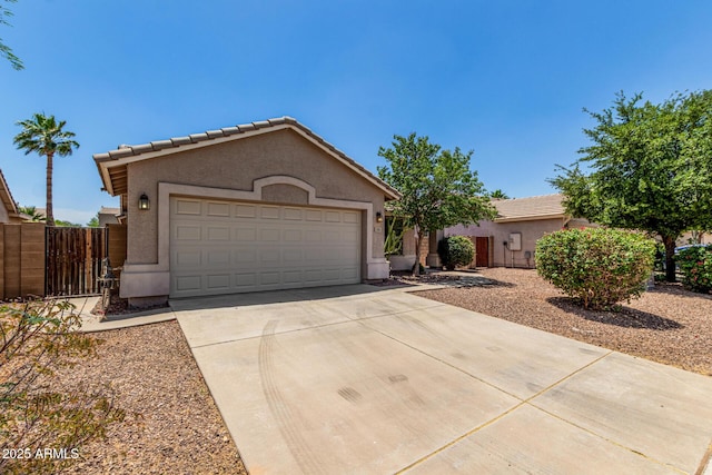 2191 W Goldmine Mountain Dr, Queen Creek, AZ 85144 - view of front facade with concrete driveway, stucco siding, an attached garage, fence, and a tiled roof