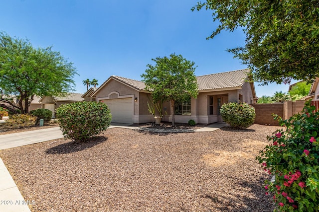 2191 W Goldmine Mountain Dr, Queen Creek, AZ 85144 - view of front facade with an attached garage, fence, a tiled roof, and stucco siding