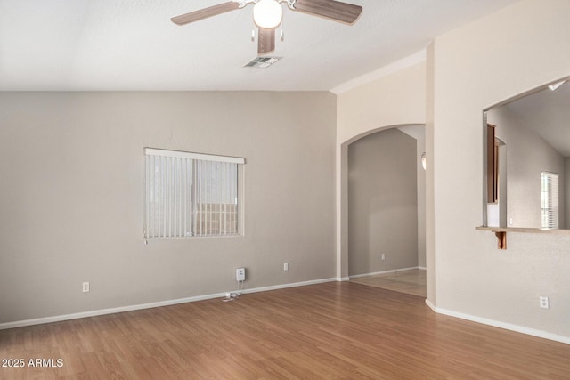 2191 W Goldmine Mountain Dr, Queen Creek, AZ 85144 - spare room with arched walkways, ceiling fan, light wood-style floors, vaulted ceiling, and baseboards