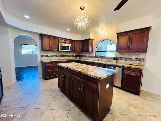 kitchen with pendant lighting, a center island, a healthy amount of sunlight, and stainless steel appliances