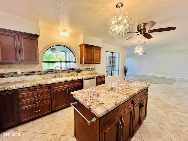 kitchen with decorative backsplash, light stone counters, sink, dishwasher, and a chandelier