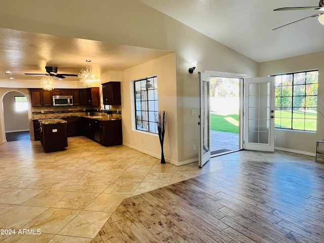 kitchen featuring a center island, lofted ceiling, ceiling fan with notable chandelier, sink, and dark brown cabinets