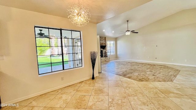 unfurnished room with a fireplace, ceiling fan with notable chandelier, light hardwood / wood-style floors, and lofted ceiling