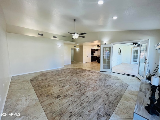 unfurnished living room featuring ceiling fan, french doors, and vaulted ceiling