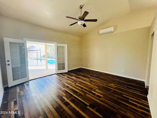 empty room with dark hardwood / wood-style flooring, lofted ceiling, a wall unit AC, and french doors