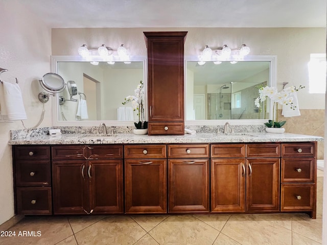 bathroom featuring a shower with door, vanity, and tile patterned flooring