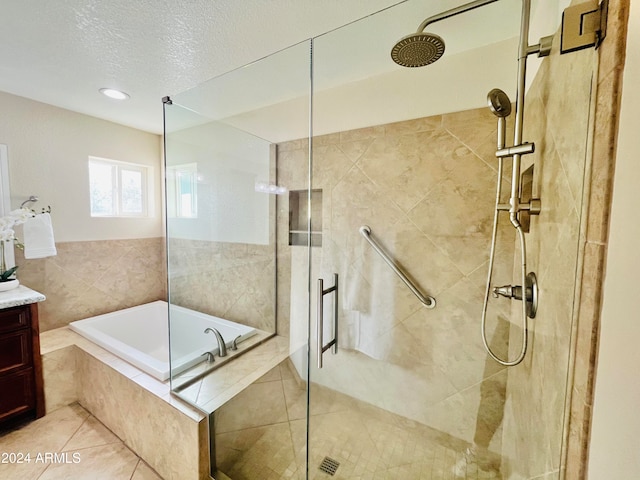 bathroom featuring separate shower and tub, tile patterned flooring, vanity, and a textured ceiling